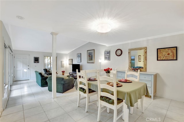 dining space with light tile patterned floors, crown molding, lofted ceiling, and ornate columns