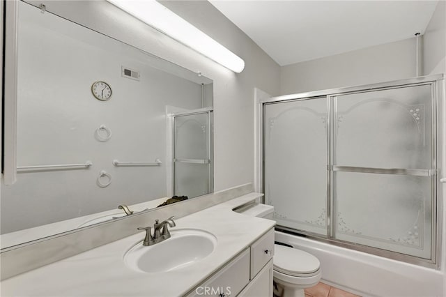 full bathroom featuring toilet, vanity, bath / shower combo with glass door, and tile patterned floors