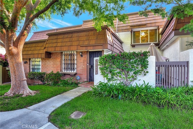 10145 Larwin Ave Unit 2, Chatsworth, CA 91311 - view of front of property with brick siding, mansard roof, a front lawn, and stucco siding
