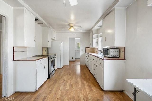 18333 Lancaster Rd, Lancaster, CA 93536 - kitchen with electric range, ceiling fan, light wood-style flooring, white cabinets, and freestanding refrigerator