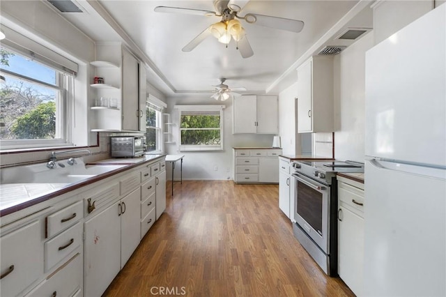 18333 Lancaster Rd, Lancaster, CA 93536 - kitchen featuring freestanding refrigerator, stainless steel range with electric stovetop, wood finished floors, white cabinetry, and ceiling fan
