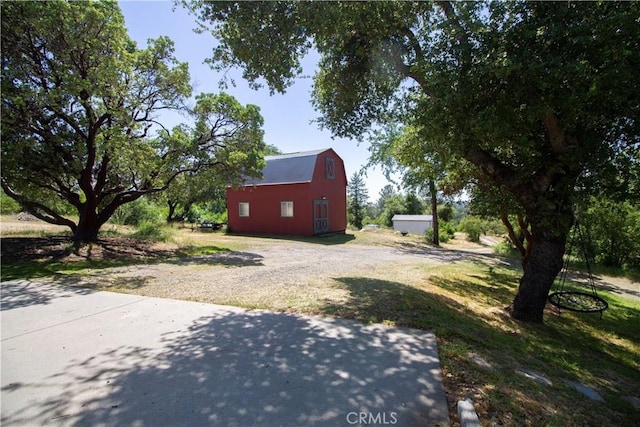 32760 Ram Ln, North Fork, CA 93643 - view of green lawn with a barn, dirt driveway, and an outdoor structure