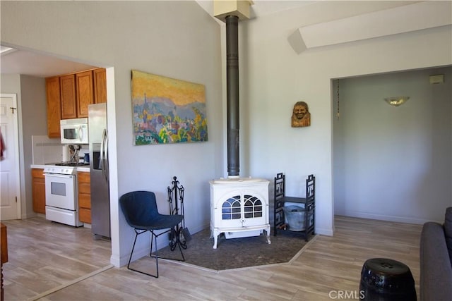 32760 Ram Ln, North Fork, CA 93643 - living room with a wood stove, light wood-style flooring, and baseboards