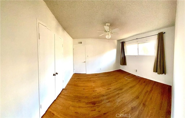 unfurnished bedroom featuring a textured ceiling, wood finished floors, and a ceiling fan