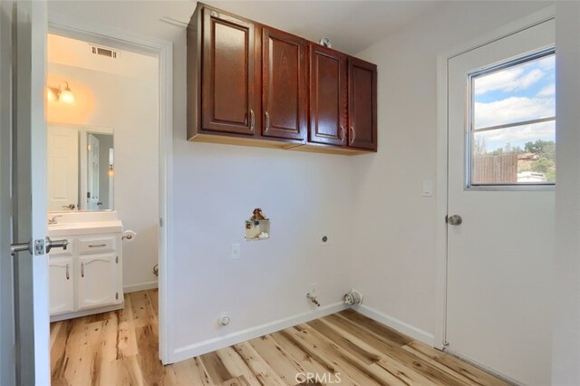 43038 Glacier Ln, Coarsegold, CA 93614 - laundry area featuring hookup for a gas dryer, light wood-style flooring, cabinet space, and hookup for an electric dryer