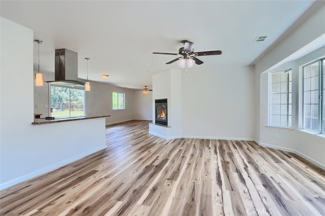 43038 Glacier Ln, Coarsegold, CA 93614 - unfurnished living room with ceiling fan, wood finished floors, baseboards, and a glass covered fireplace
