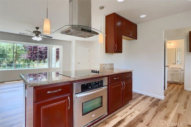 43038 Glacier Ln, Coarsegold, CA 93614 - kitchen featuring oven, wall chimney exhaust hood, light wood finished floors, black electric cooktop, and ceiling fan