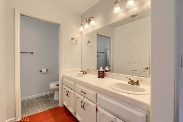 43038 Glacier Ln, Coarsegold, CA 93614 - bathroom featuring toilet, double vanity, and baseboards