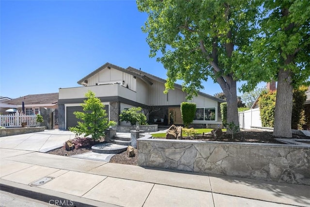 25232 Grissom Rd, Laguna Hills, CA 92653 - view of front of home with concrete driveway, a garage, fence, and stone siding