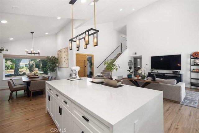25232 Grissom Rd, Laguna Hills, CA 92653 - kitchen featuring high vaulted ceiling, light wood-type flooring, white cabinets, recessed lighting, and pendant lighting