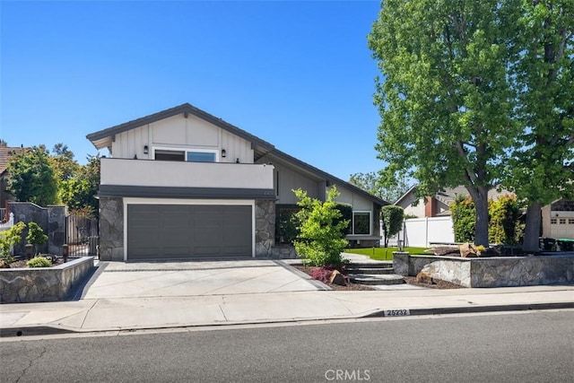 25232 Grissom Rd, Laguna Hills, CA 92653 - view of front facade with stone siding, driveway, fence, and a balcony