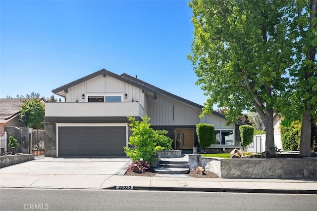 25232 Grissom Rd, Laguna Hills, CA 92653 - view of front of home featuring board and batten siding, concrete driveway, a garage, fence, and a gate