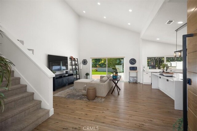 25232 Grissom Rd, Laguna Hills, CA 92653 - living area featuring high vaulted ceiling, wood finished floors, stairs, and recessed lighting