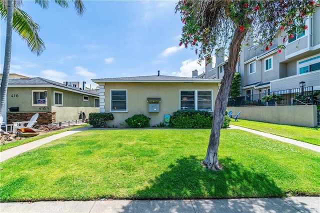 bungalow-style home with stucco siding and a front yard