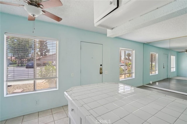 82075 Country Club Dr Unit 31, Indio, CA 92201 - kitchen with tile countertops, a ceiling fan, a textured ceiling, light tile patterned floors, and baseboards