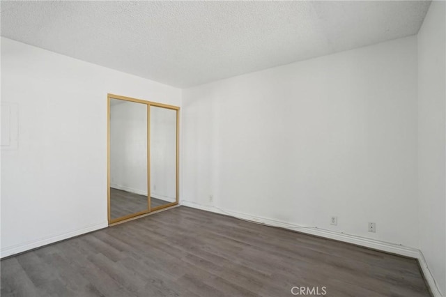 82075 Country Club Dr Unit 31, Indio, CA 92201 - unfurnished bedroom with wood finished floors, a closet, baseboards, and a textured ceiling