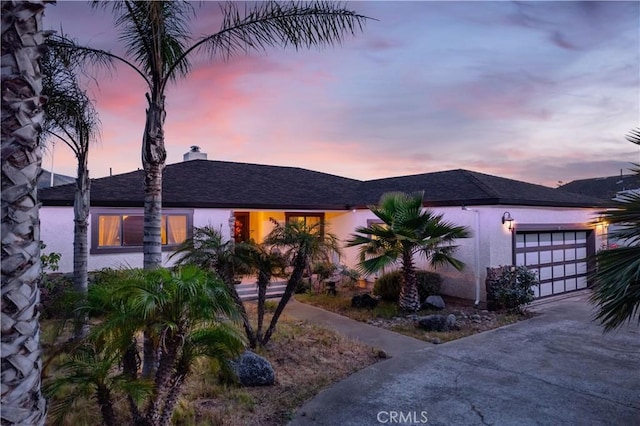 7795 Richard Dr, Lucerne, CA 95458 - view of front of home with concrete driveway, an attached garage, a chimney, and stucco siding