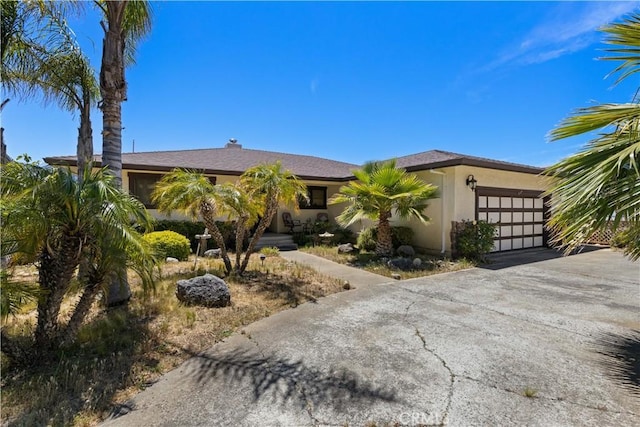 7795 Richard Dr, Lucerne, CA 95458 - view of front of house featuring an attached garage, stucco siding, and driveway
