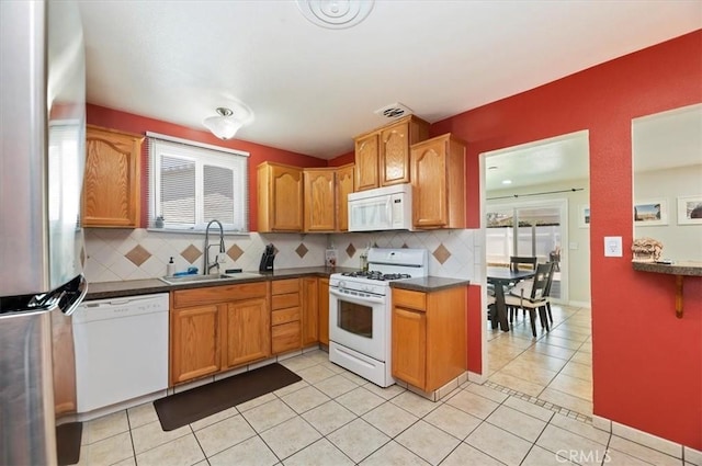 4487 Monticello Ave, Riverside, CA 92503 - kitchen with white appliances, a sink, backsplash, dark countertops, and light tile patterned floors