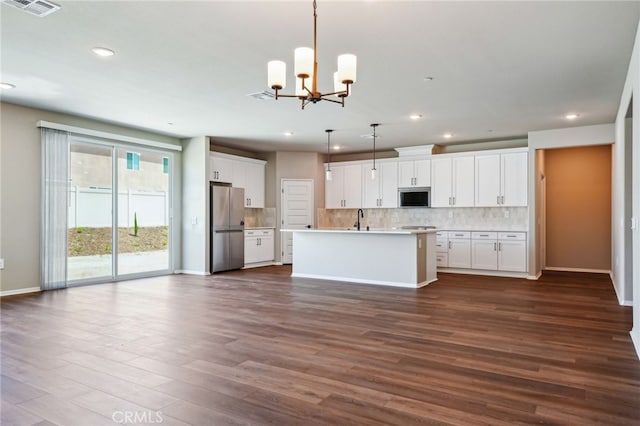 kitchen with appliances with stainless steel finishes, open floor plan, a sink, recessed lighting, and tasteful backsplash