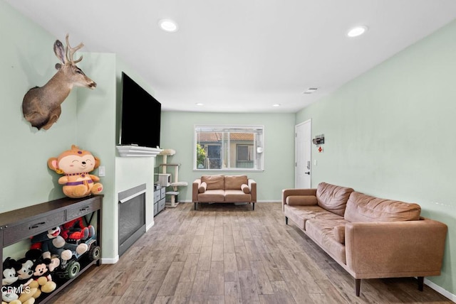 126 E Ventura St Unit F, Santa Paula, CA 93060 - living room featuring wood finished floors, a glass covered fireplace, and recessed lighting