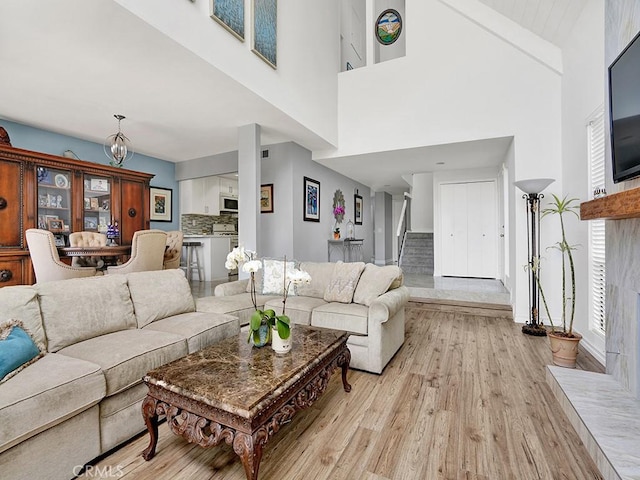 3842 Montego Dr, Huntington Beach, CA 92649 - living room with light wood-style floors, stairs, and a towering ceiling