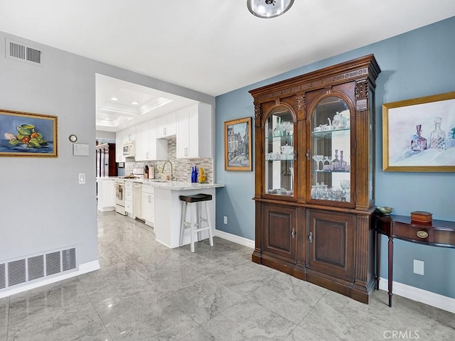 3842 Montego Dr, Huntington Beach, CA 92649 - bar featuring white appliances, baseboards, a tray ceiling, backsplash, and a sink