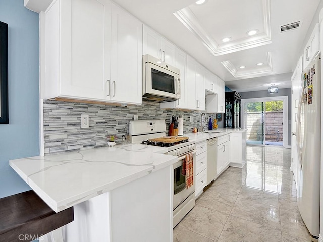 3842 Montego Dr, Huntington Beach, CA 92649 - kitchen with white appliances, a sink, decorative backsplash, a peninsula, and crown molding