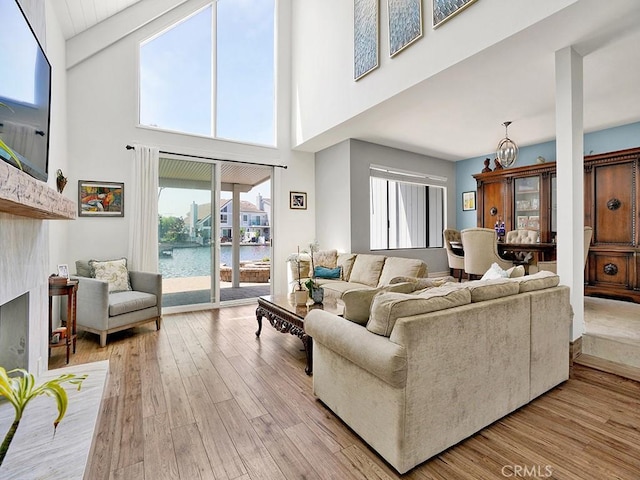 3842 Montego Dr, Huntington Beach, CA 92649 - living room with high vaulted ceiling, a water view, light wood-style floors, beam ceiling, and a fireplace with raised hearth