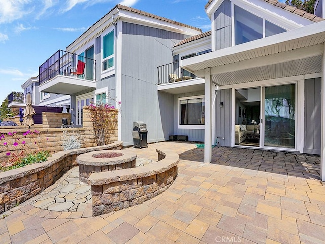 3842 Montego Dr, Huntington Beach, CA 92649 - rear view of property featuring a fire pit, a balcony, a patio area, and a tiled roof