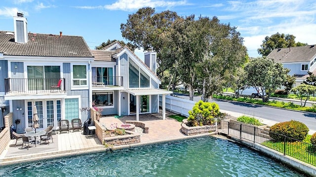 3842 Montego Dr, Huntington Beach, CA 92649 - back of house featuring a balcony, french doors, a chimney, and a patio area