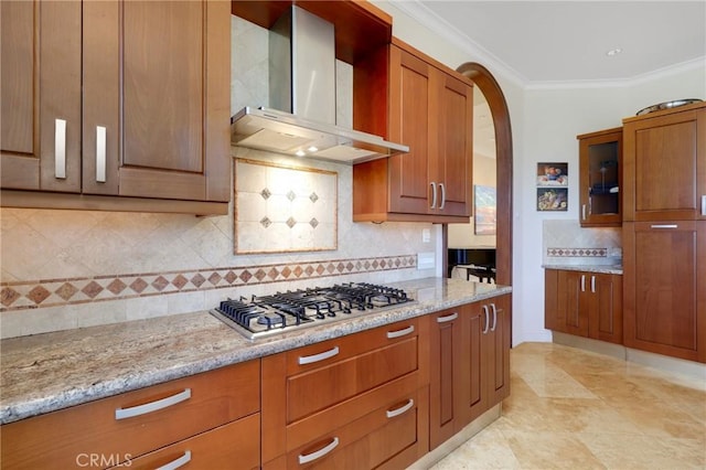24182 Torena Cir, Mission Viejo, CA 92691 - kitchen with wall chimney exhaust hood, stainless steel gas cooktop, decorative backsplash, light stone counters, and ornamental molding
