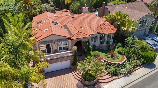 24182 Torena Cir, Mission Viejo, CA 92691 - mediterranean / spanish-style home featuring a tiled roof, a garage, a chimney, decorative driveway, and stucco siding