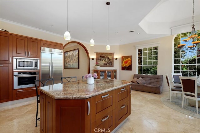 24182 Torena Cir, Mission Viejo, CA 92691 - kitchen featuring built in appliances, light stone counters, a center island, and pendant lighting