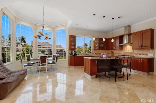 24182 Torena Cir, Mission Viejo, CA 92691 - kitchen featuring a chandelier, wall chimney range hood, a kitchen island, glass insert cabinets, and tasteful backsplash
