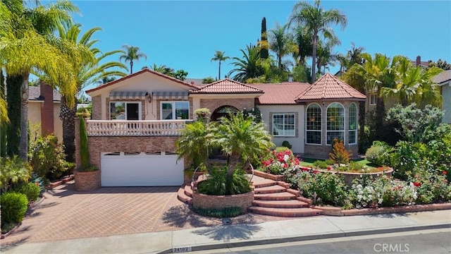 24182 Torena Cir, Mission Viejo, CA 92691 - mediterranean / spanish-style home with decorative driveway, a tile roof, a garage, a balcony, and stucco siding