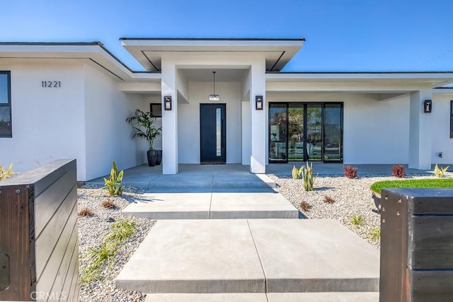 entrance to property featuring stucco siding