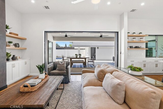living room with ceiling fan, wood finished floors, and recessed lighting
