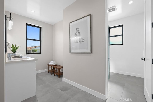 hall featuring baseboards and recessed lighting