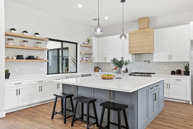 kitchen featuring open shelves, white cabinets, light countertops, a kitchen island, and recessed lighting