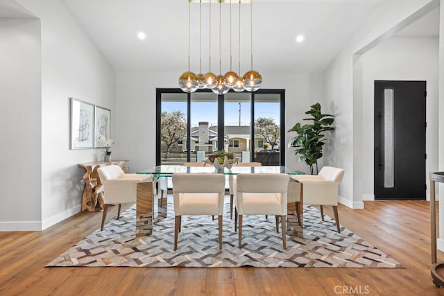 dining area featuring wood finished floors, baseboards, recessed lighting, and vaulted ceiling