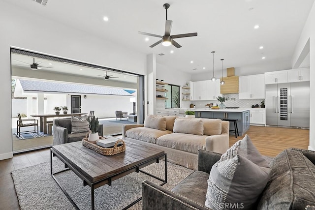 living room featuring a ceiling fan, recessed lighting, and light wood finished floors