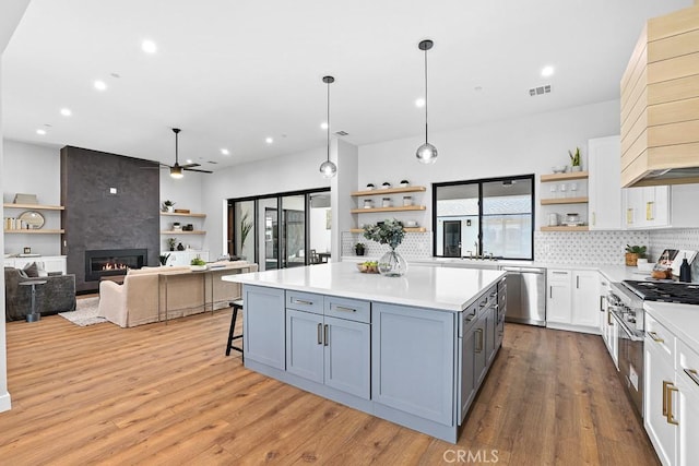 kitchen featuring open shelves, dishwasher, light countertops, and recessed lighting