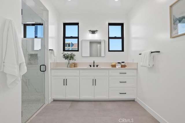 full bathroom with plenty of natural light, a marble finish shower, baseboards, and vanity