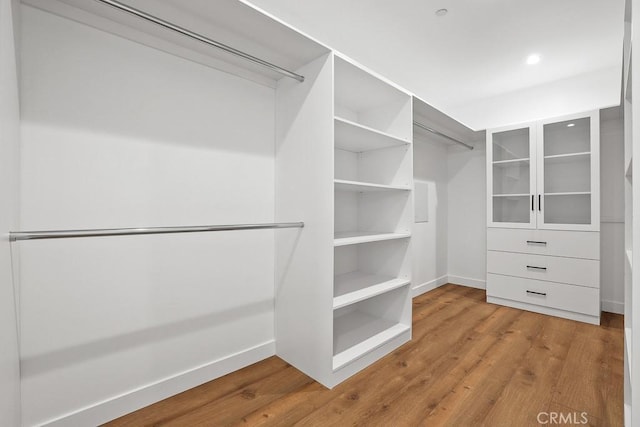 walk in closet with wood finished floors