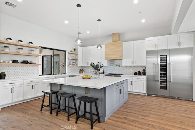 kitchen featuring stainless steel built in refrigerator, open shelves, premium range hood, white cabinets, and recessed lighting