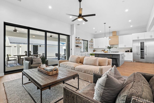 living room with ceiling fan, light wood-style floors, and recessed lighting