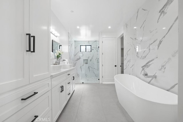 bathroom featuring vanity, a marble finish shower, a soaking tub, and recessed lighting
