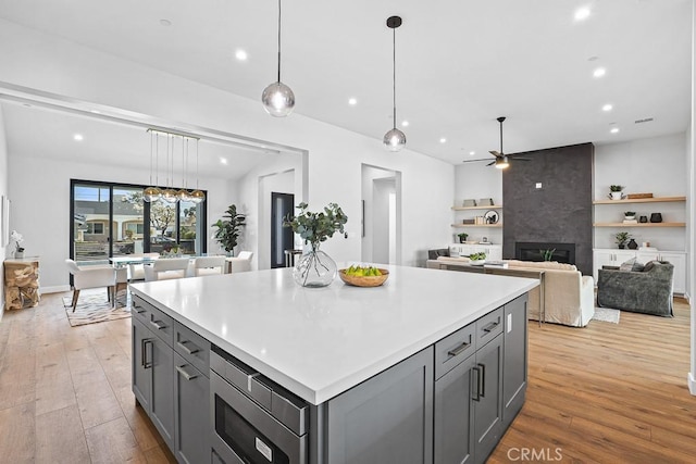 kitchen with gray cabinetry, recessed lighting, ceiling fan, a center island, and light wood-type flooring