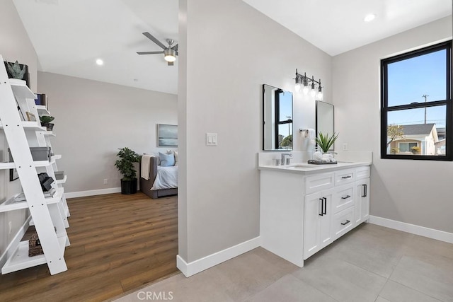 bathroom featuring ceiling fan, baseboards, vanity, ensuite bath, and recessed lighting